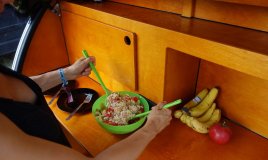 Preparing food in a galley of a teardrop trailer.